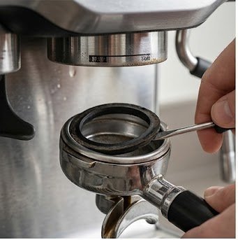 Removing a worn espresso machine group head gasket with a flathead screwdriver